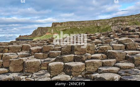 atlantic coastline with Volcanic hexagonal basalt columns of Giant`s Causeway at sunset in Northern Ireland Stock Photo